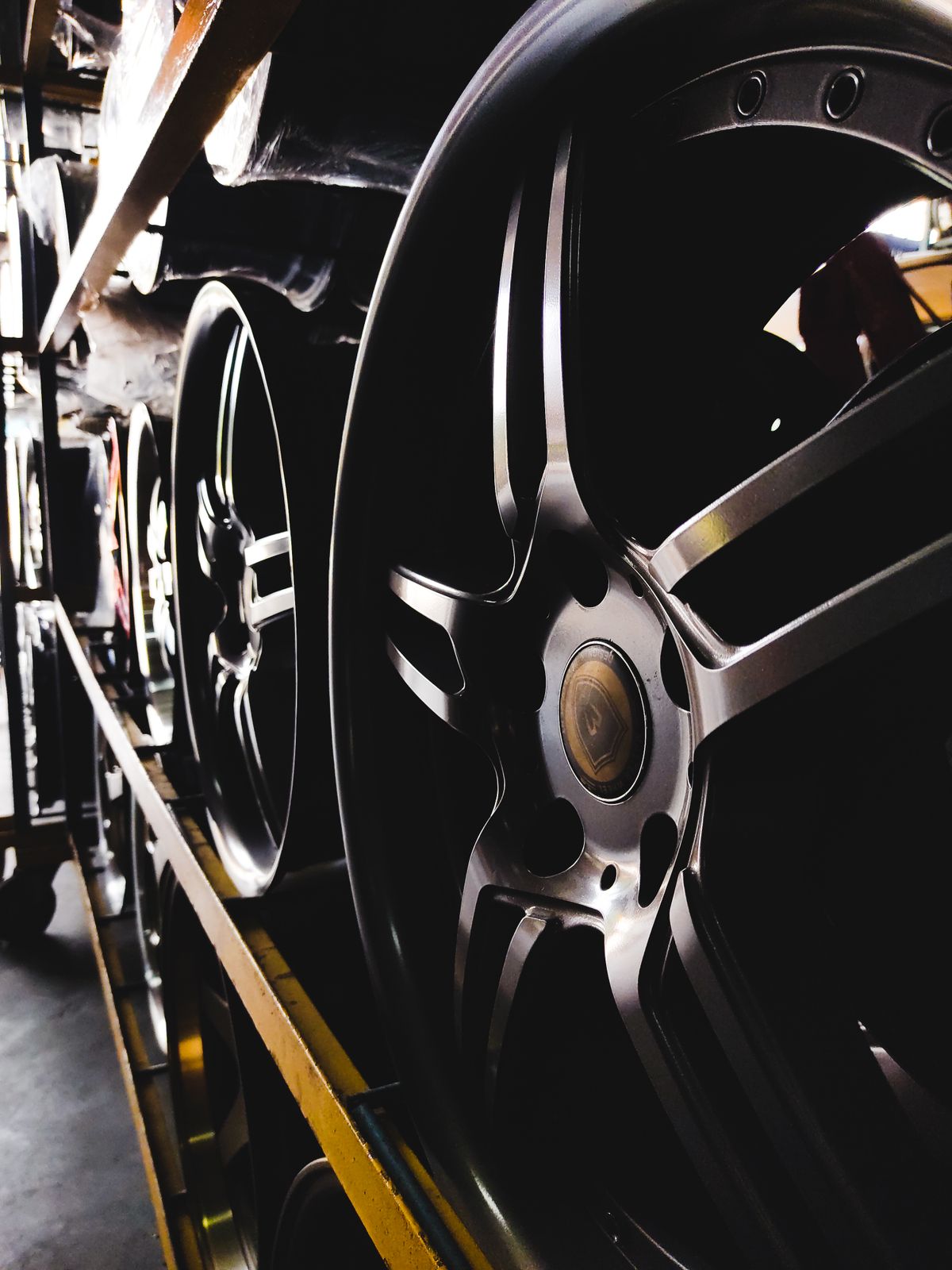 Alloy wheels lined up on workshop shelves