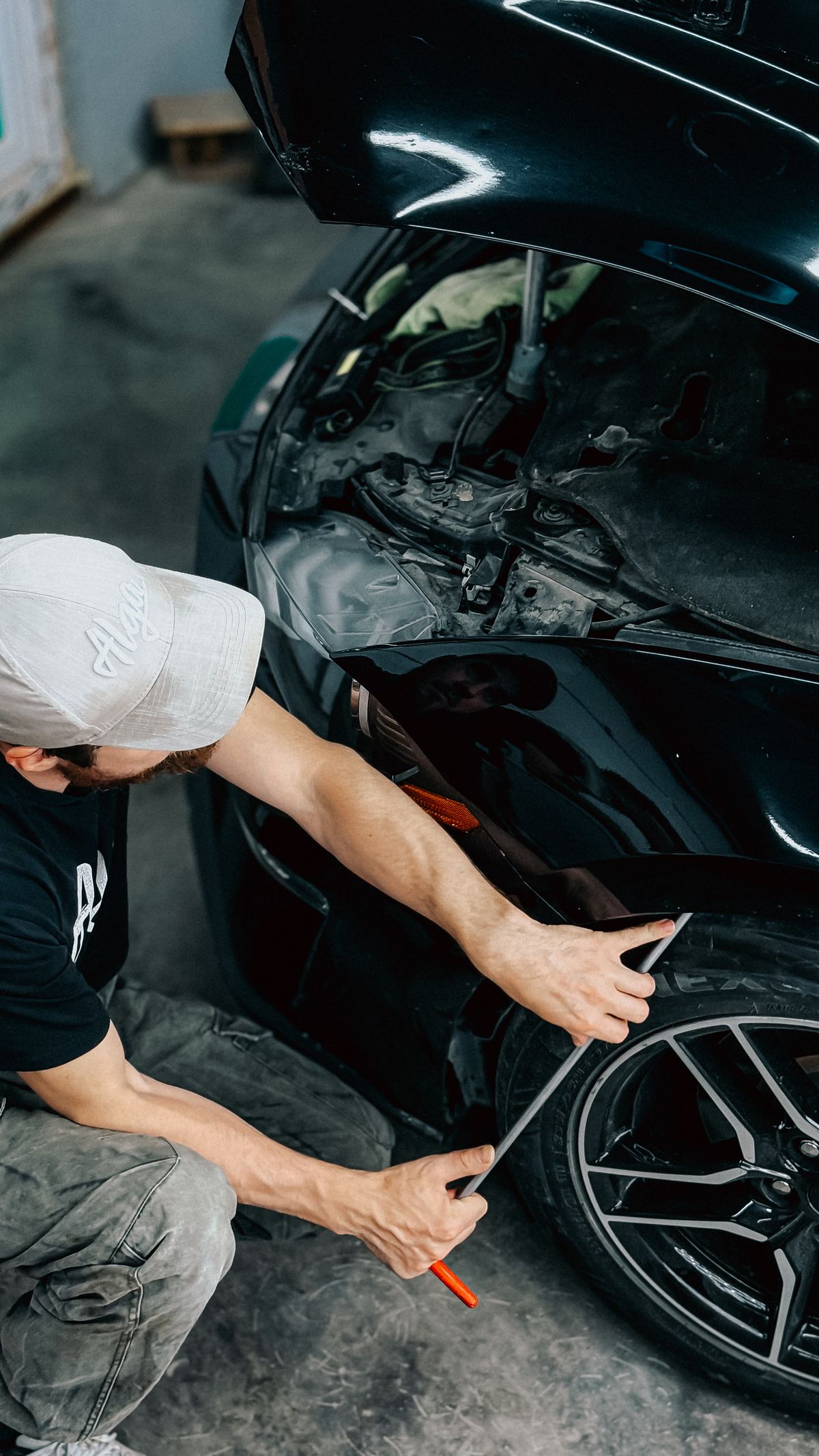 Mechanic repairing a car bumper in a workshop