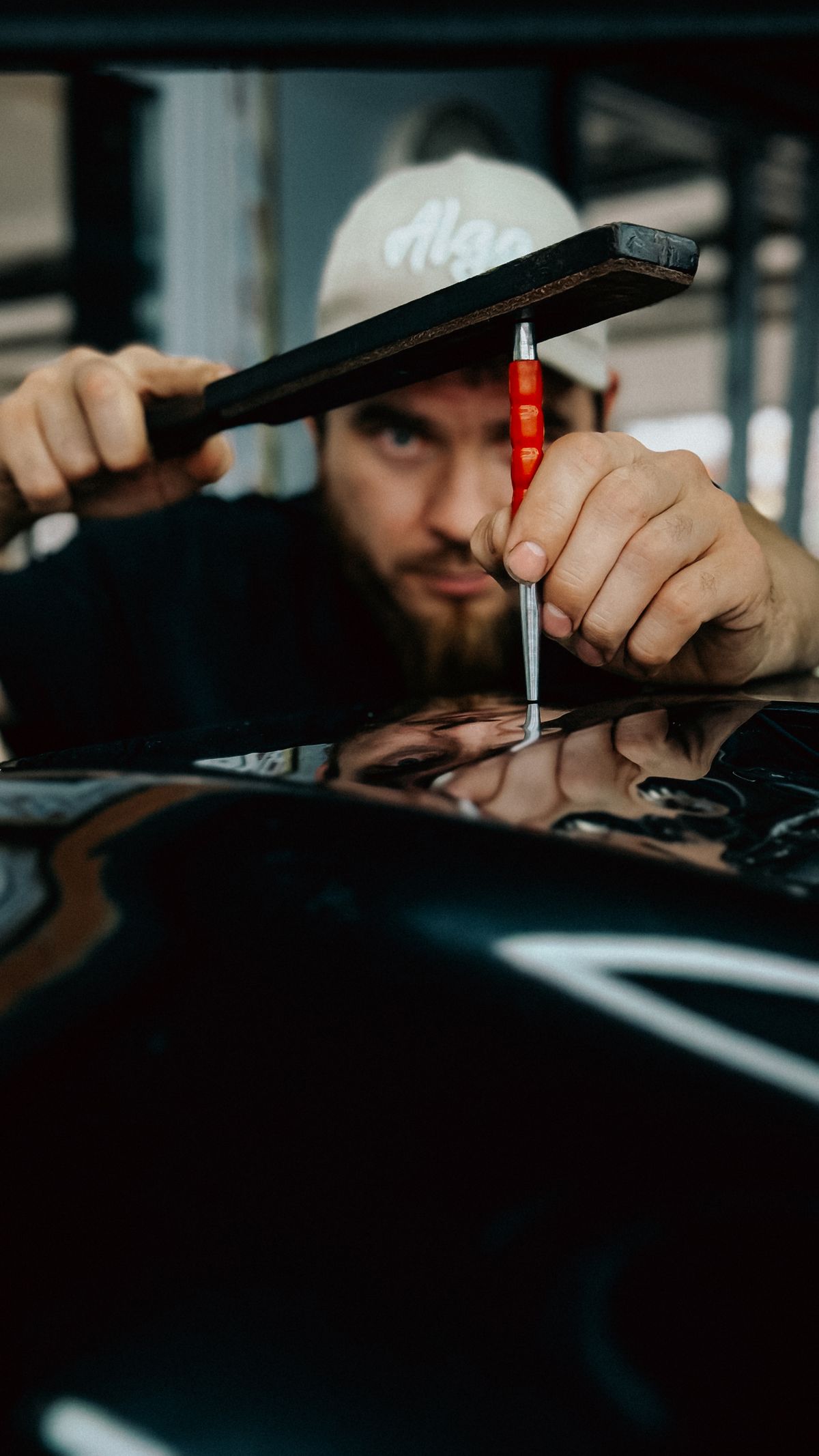 Technician repairing a dent in a car panel